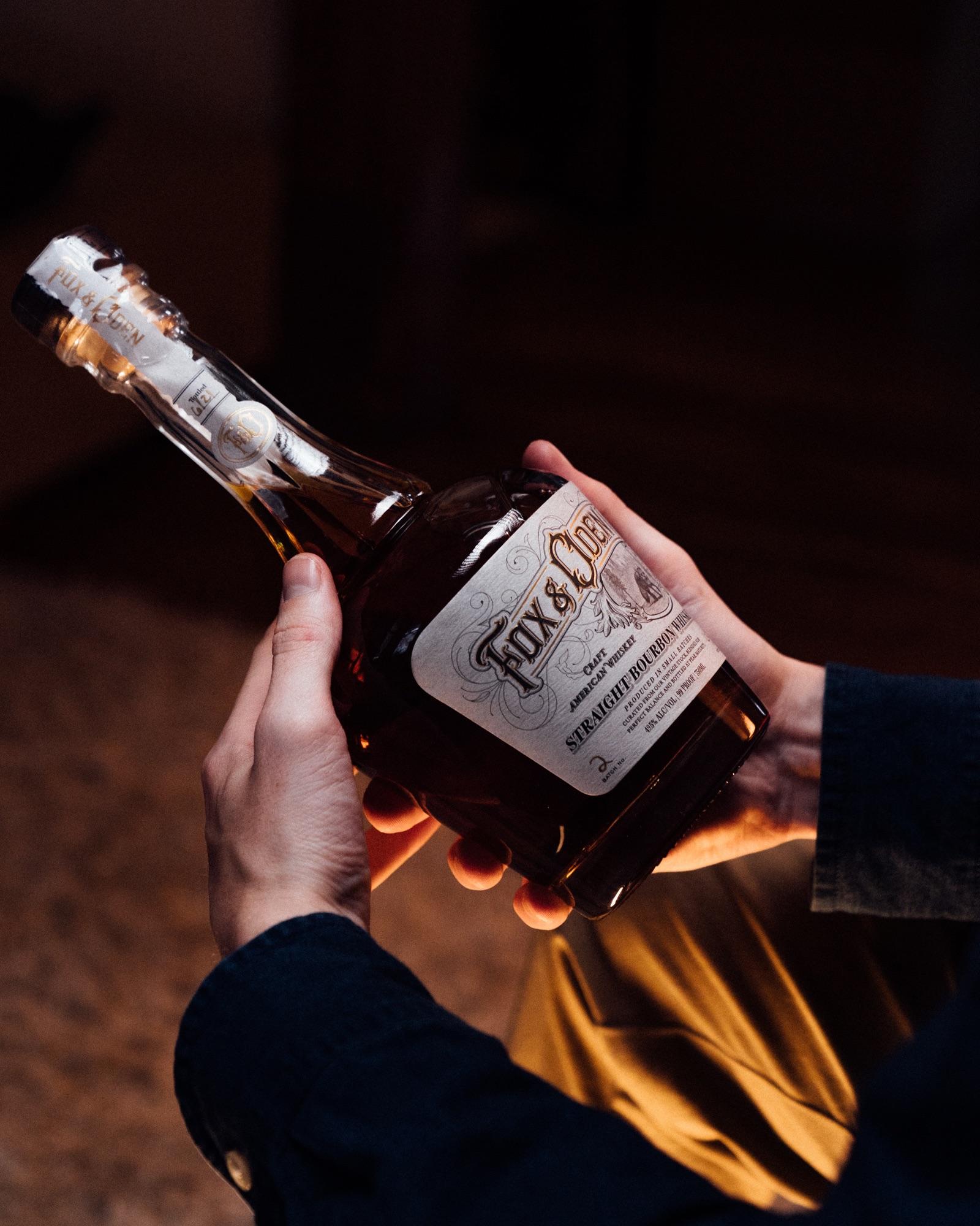 A bottle of Fox & Oden Straight Bourbon in hand